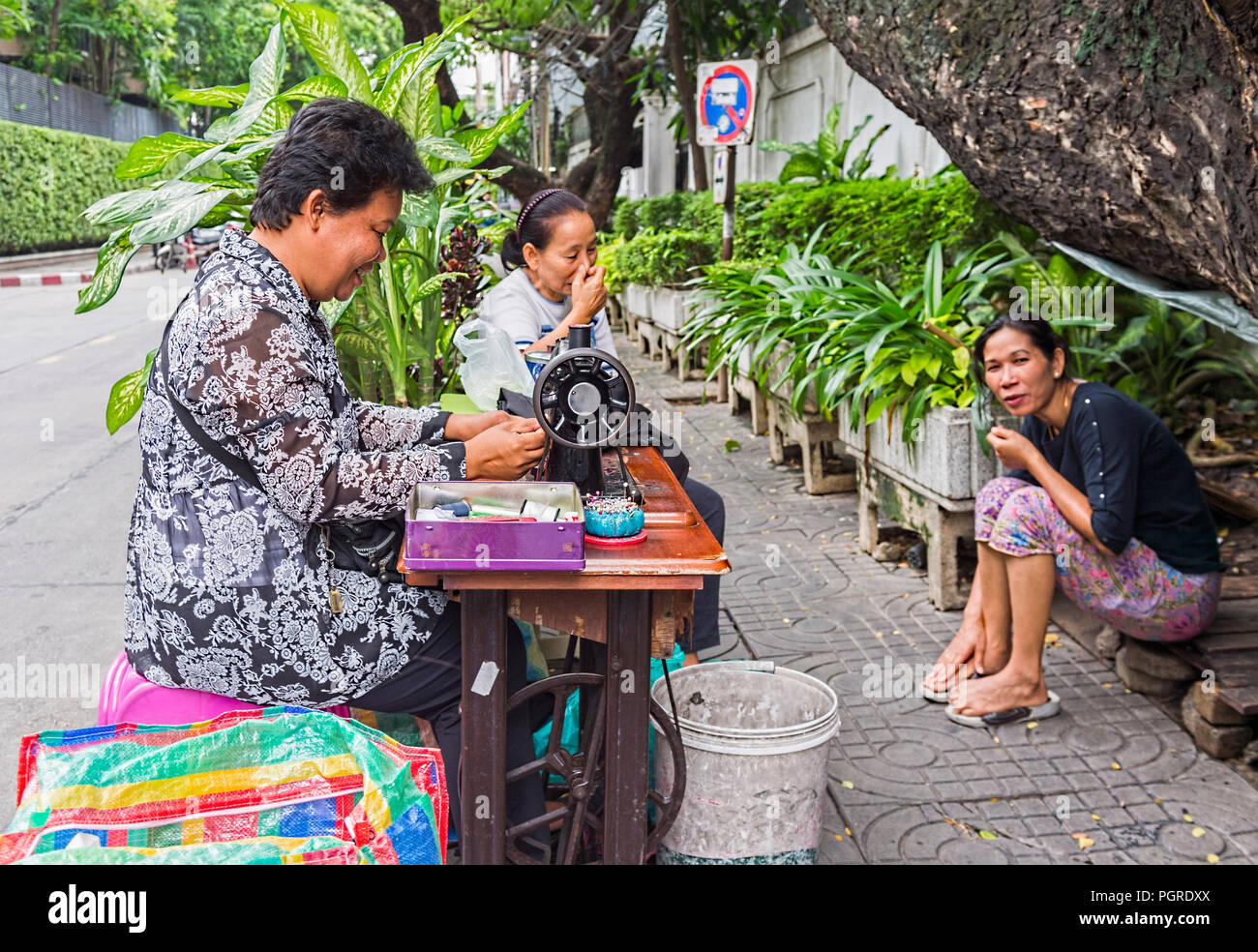 Thai ladies using sewing machine on a street in Bangkok Thailand Stock Photo
