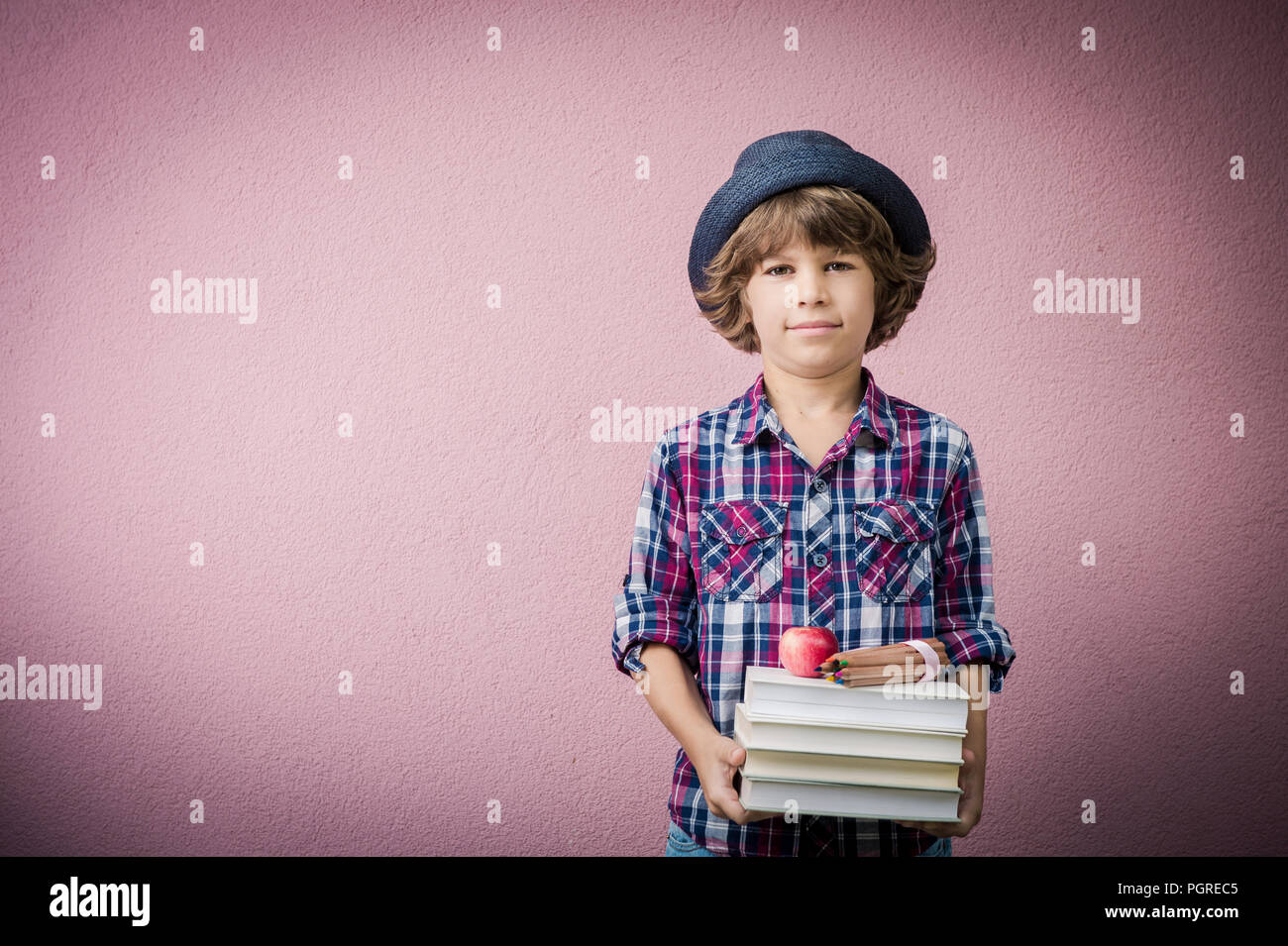 Little boy holding stack of books ready to go back to school Stock ...
