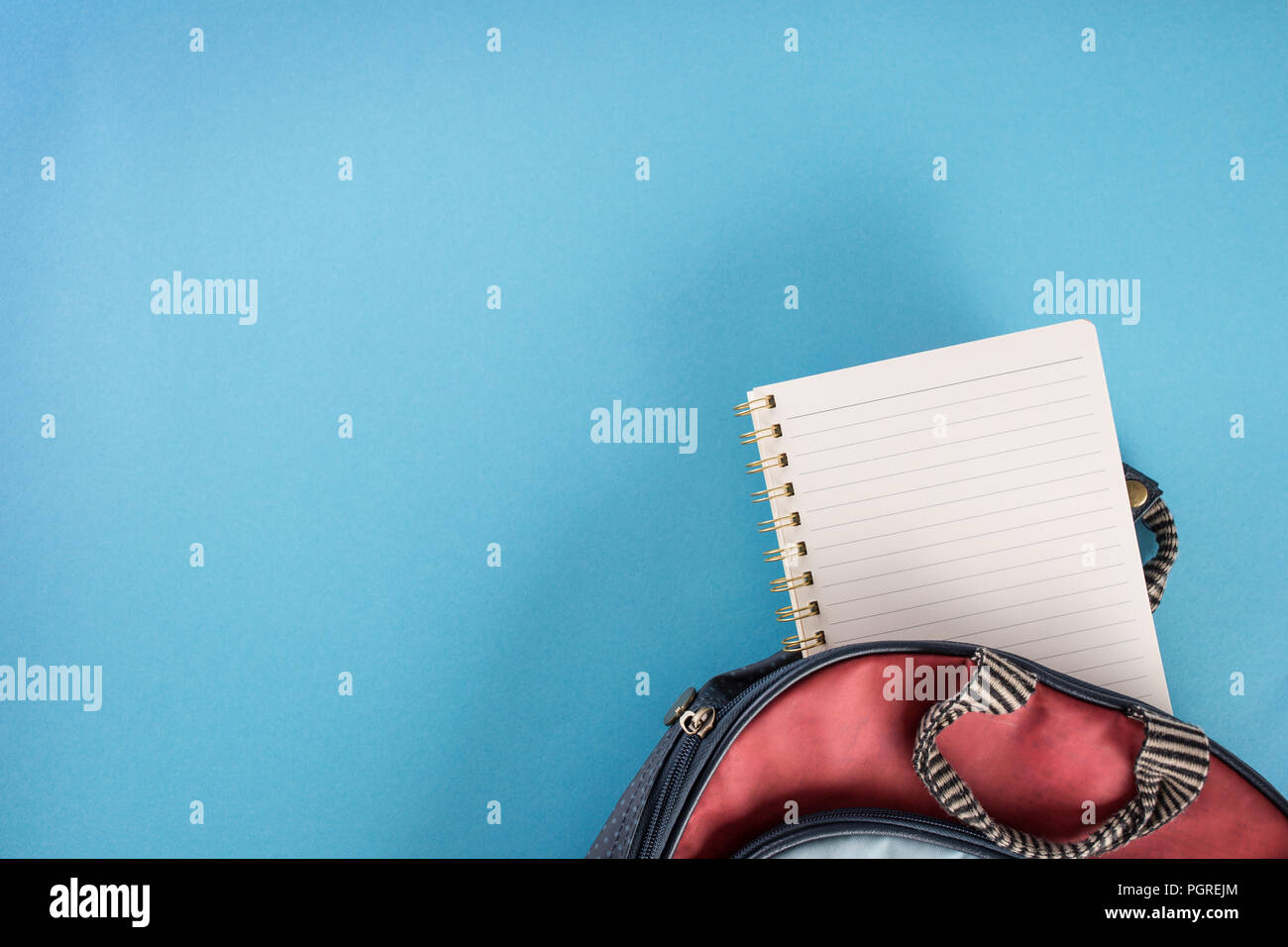 School backpack and notebook on blue background. Stock Photo