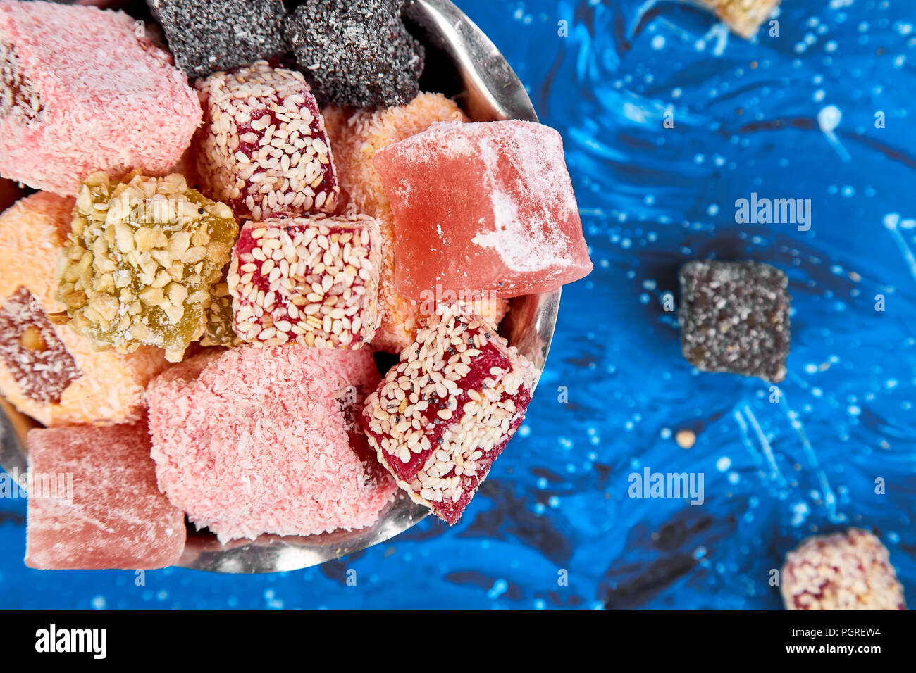 Set of various Turkish delight in traditional silver bowl l on blue background.  Middle Eastern dessert. Top view. Copy space. Falt lay Stock Photo