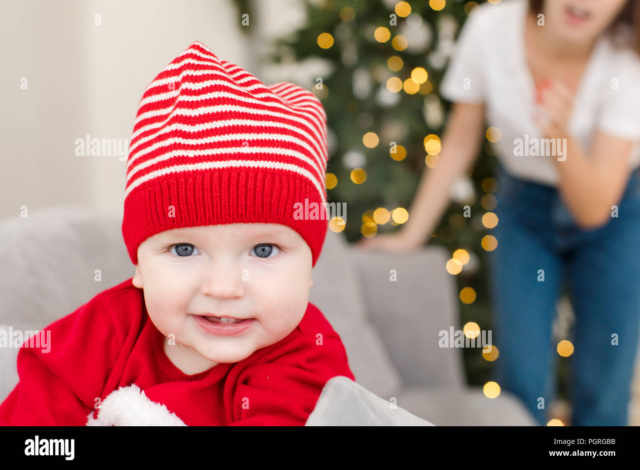 Little infant in striped hat looking at camera Stock Photo