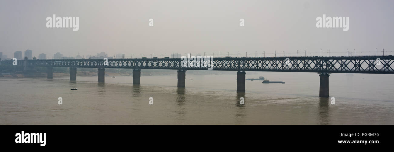 Panorama of old Wuhan Yangtze Great Bridge a truss double-deck road and rail bridge across the Yangtze River in Wuhan China on high peak pollution day Stock Photo