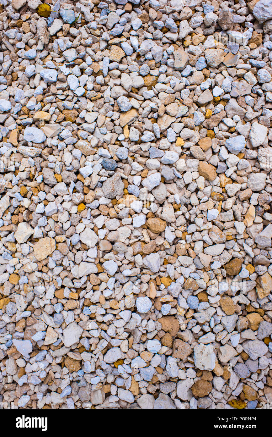 Tan, White, and Grey rocks pebbles gravel with blurred bokeh background edges and closeup fine detail for driveways, landscaping, and French drains Stock Photo