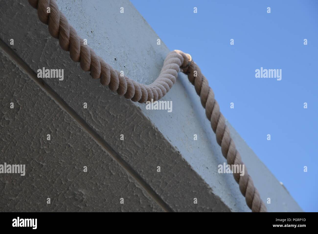 Rope a jute rope adorning an otherwise plain concrete overhang Stock