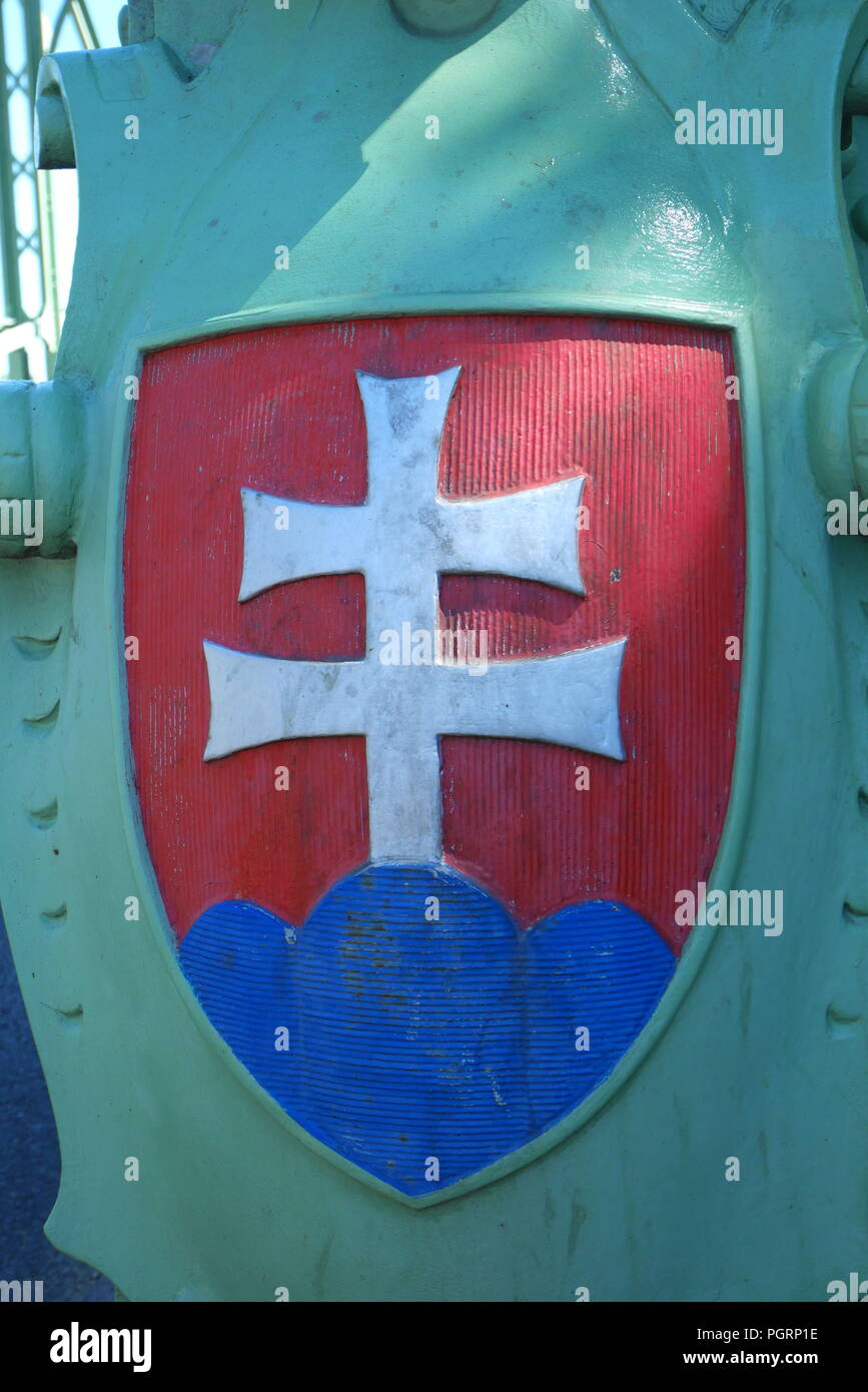 Coat of arms of Slovakia with a red shield, silver double cross and three blue mountain peaks on the Maria Valeria Bridge, Sturovo, Slovakia Stock Photo