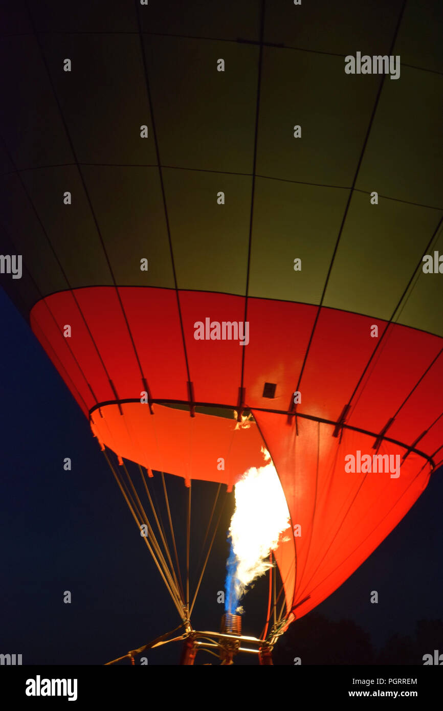 hot air balloon lit at night, hot air balloon with a yellow fire from a burner by night Stock Photo