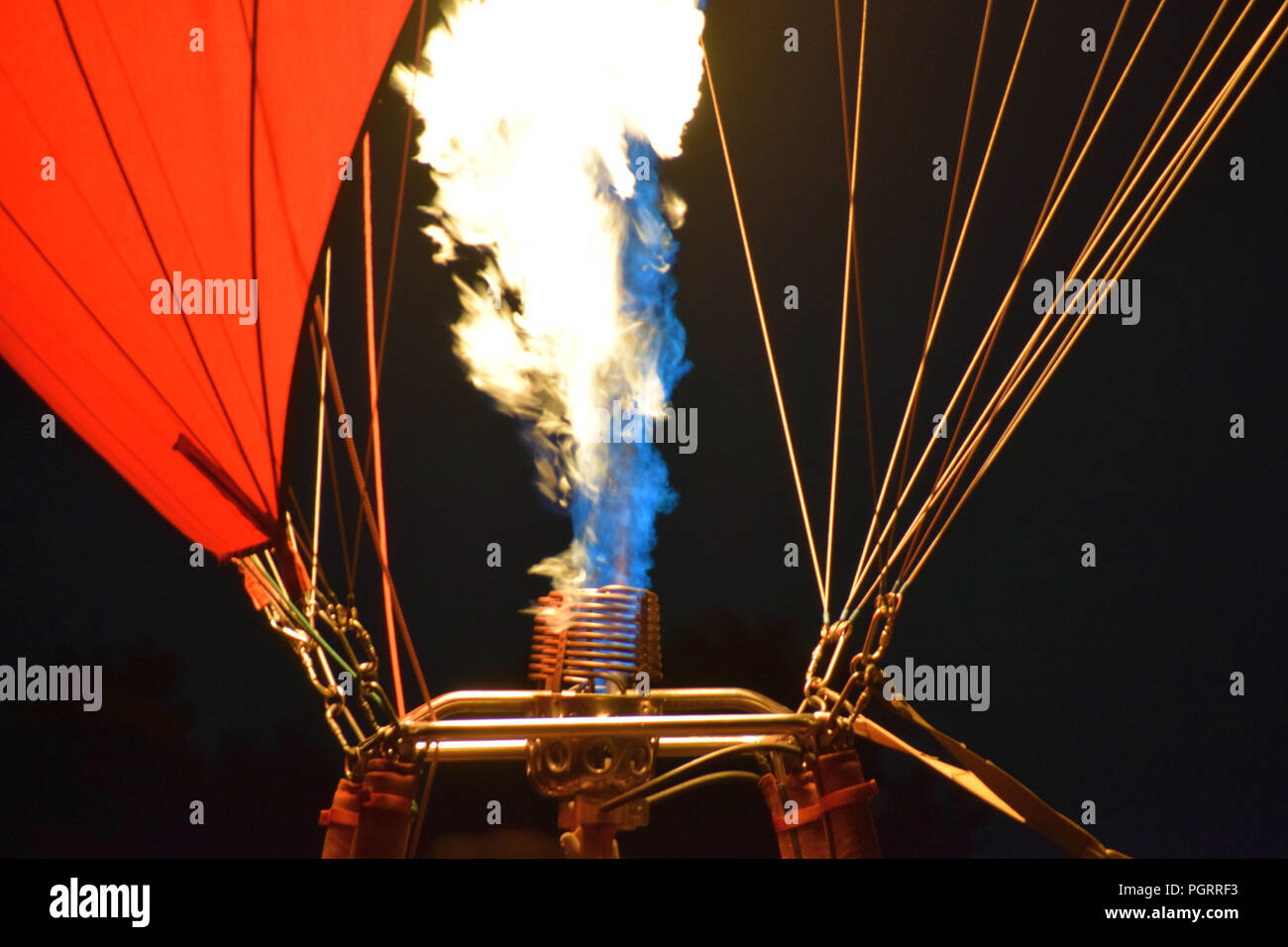 macro shot of a hot air balloon burner in front of black background, hot air balloon with a yellow fire from a burner by night Stock Photo