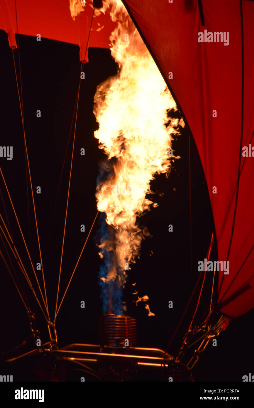 close-up view of a burner of a hot air balloon with blazing flames, hot air balloon with a yellow fire from a burner by night Stock Photo