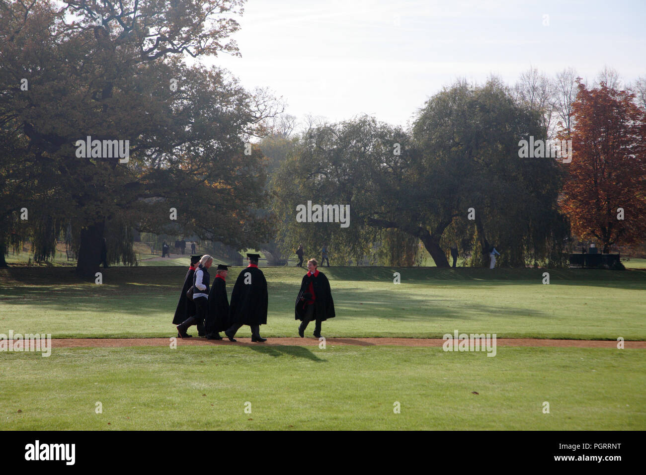 Choristers walk across St. John's Meadow, St. John's College, Cambridge, England, UK Stock Photo