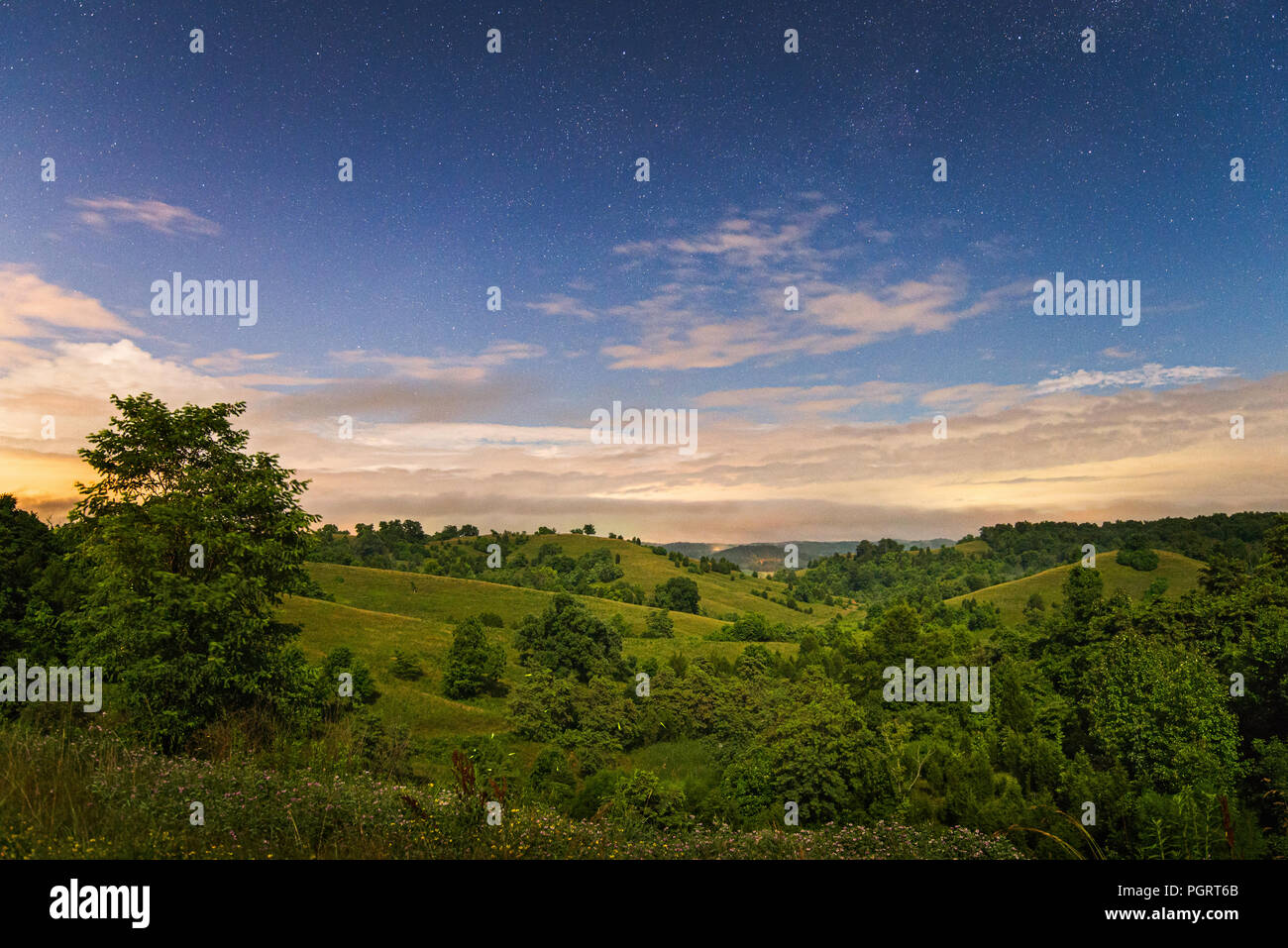 Moon and star light highlight the gentle rolling hills of the country side along the Kanawha River Valley in Henderson, West Virginia. Stock Photo