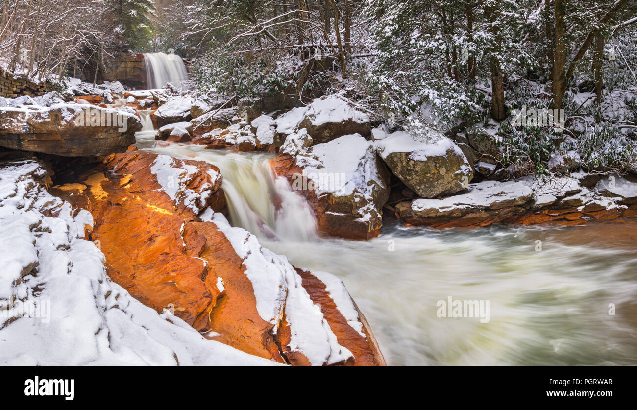 Winter visits Douglas Falls in Thomas, West Virginia, with a layer of snow covering the orange, iron laden sandstone created from acid mine drainage. Stock Photo