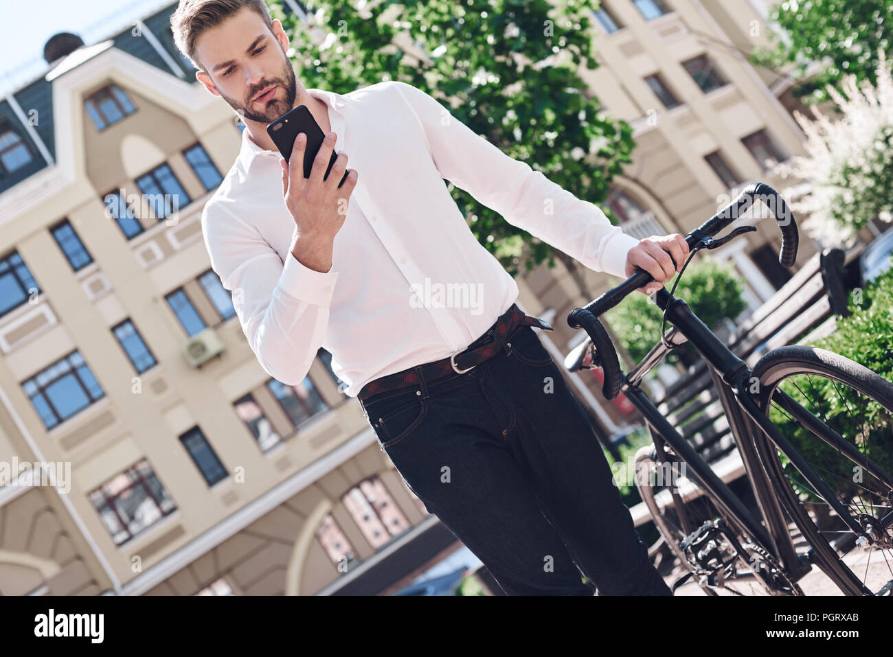 People, communication, technology, leisure and lifestyle - hipster man with smartphone on fixed gear bike chatting phone Stock Photo