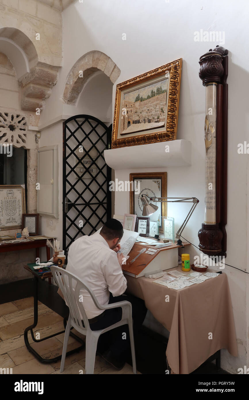A religious Jewish "Stam" calligrapher writing biblical scripture on parchment next to the world