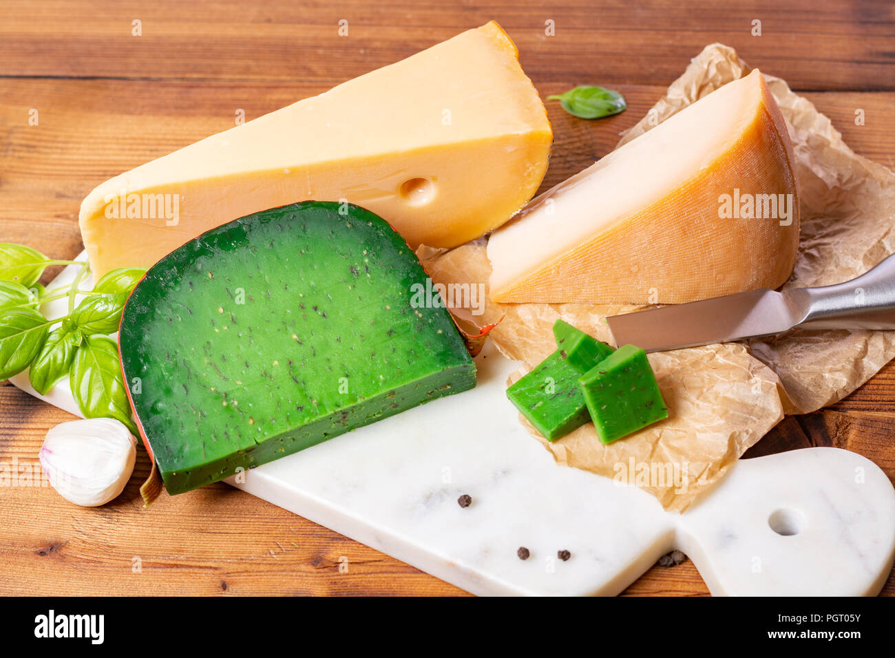 Piece of green pesto hard Dutch cheese made with fresh basil herb, old Dutch cow and goat