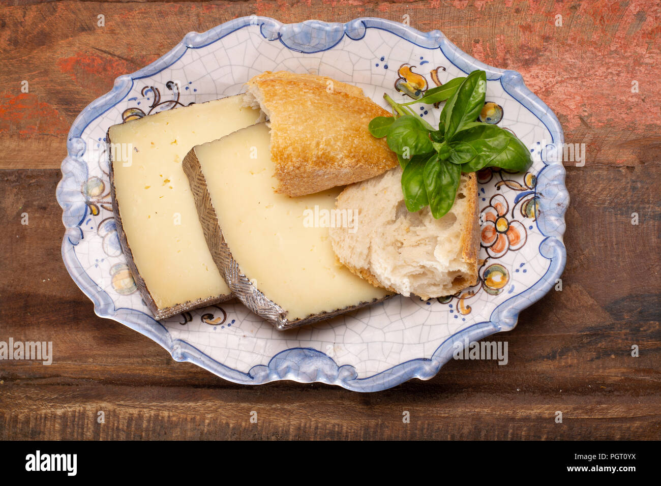 Two pieces of Manchego, queso manchego, cheese made in La Mancha region of  Spain from the milk of sheep of the manchega breed served on traditional sp  Stock Photo - Alamy, image size:1300x956