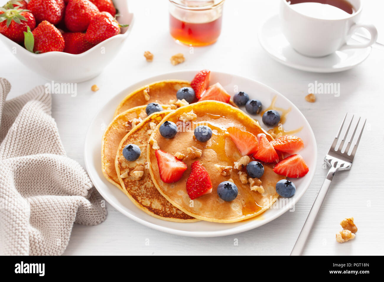 pancakes with blueberry strawberry honey and nuts for breakfast Stock