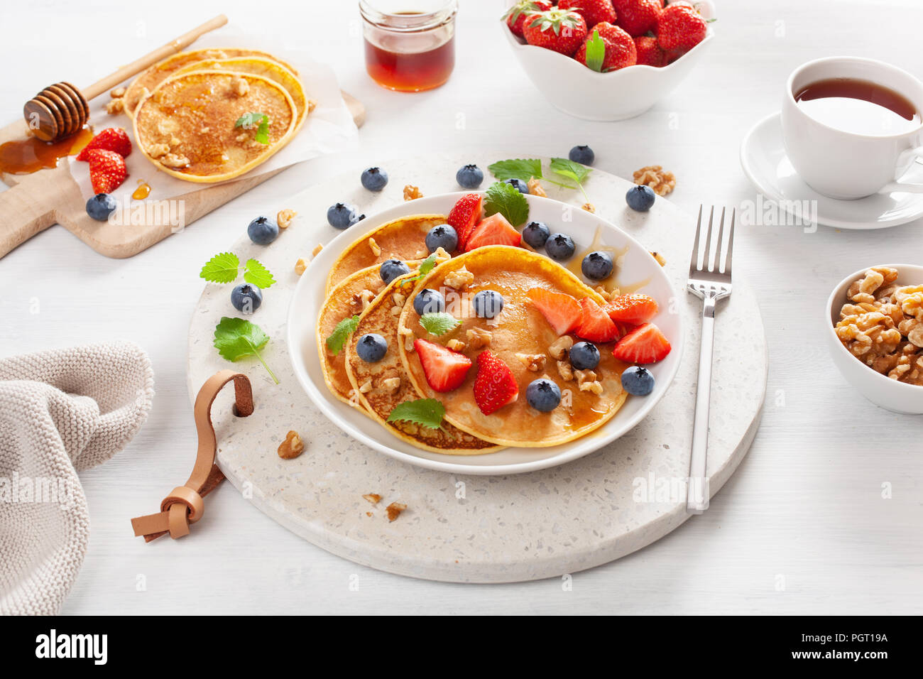 pancakes with blueberry strawberry honey and nuts for breakfast Stock