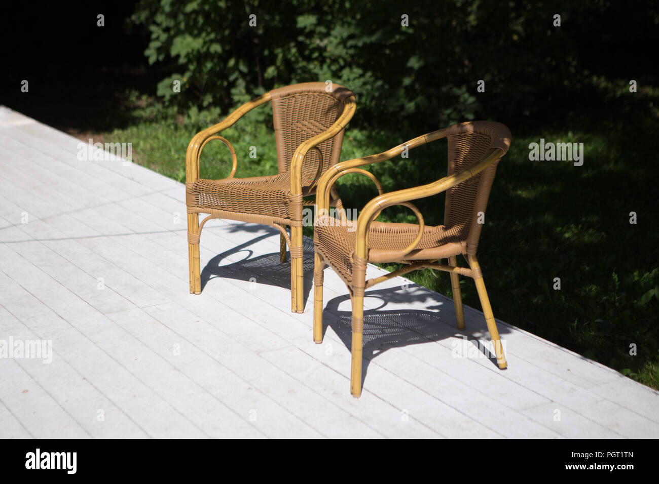 Two wicker chairs against the sky and palm trees Stock Photo - Alamy