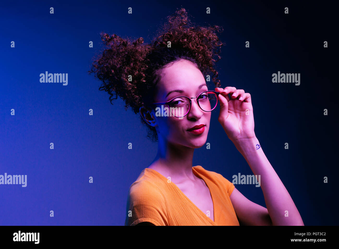 Smart young girl holding her glasses Stock Photo