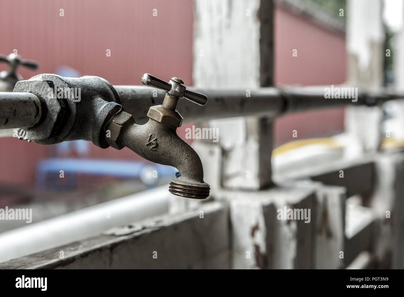 A conceptual photo of an old industrial water spigot and a pipe. Stock Photo