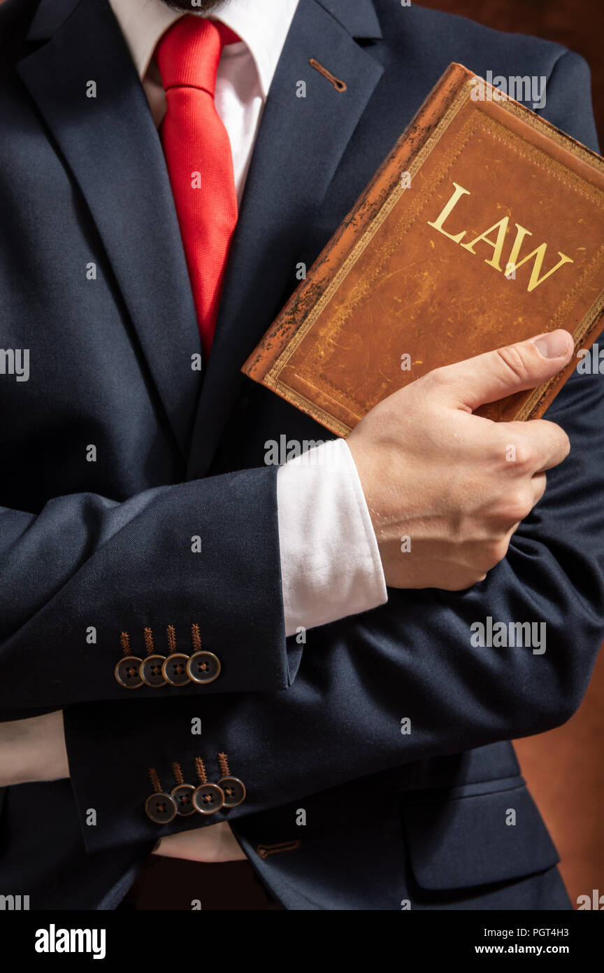 Lawyer stands with crossed hands with law book. Stock Photo