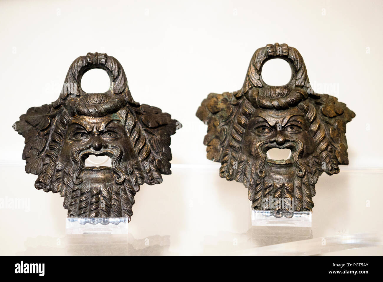Two bronze handles in the form of a silen mask surrounded by vine leaves, imperial Roman age - National Roman Museum in Palazzo Massimo alle Terme - Rome, Italy Stock Photo