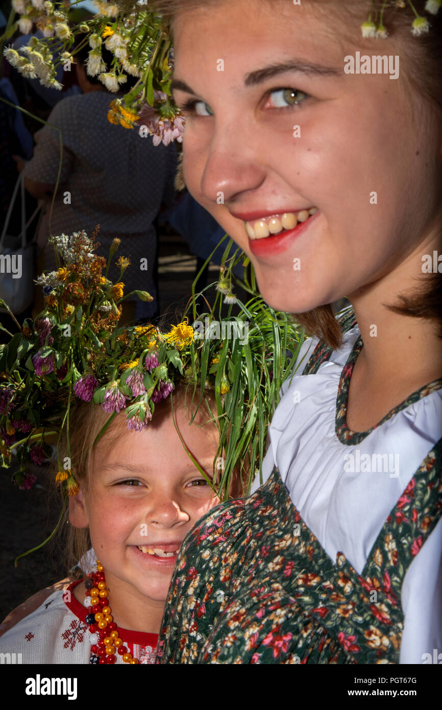 Girls in Russian sarafans and with flower wreaths on their heads during a village holiday Stock Photo