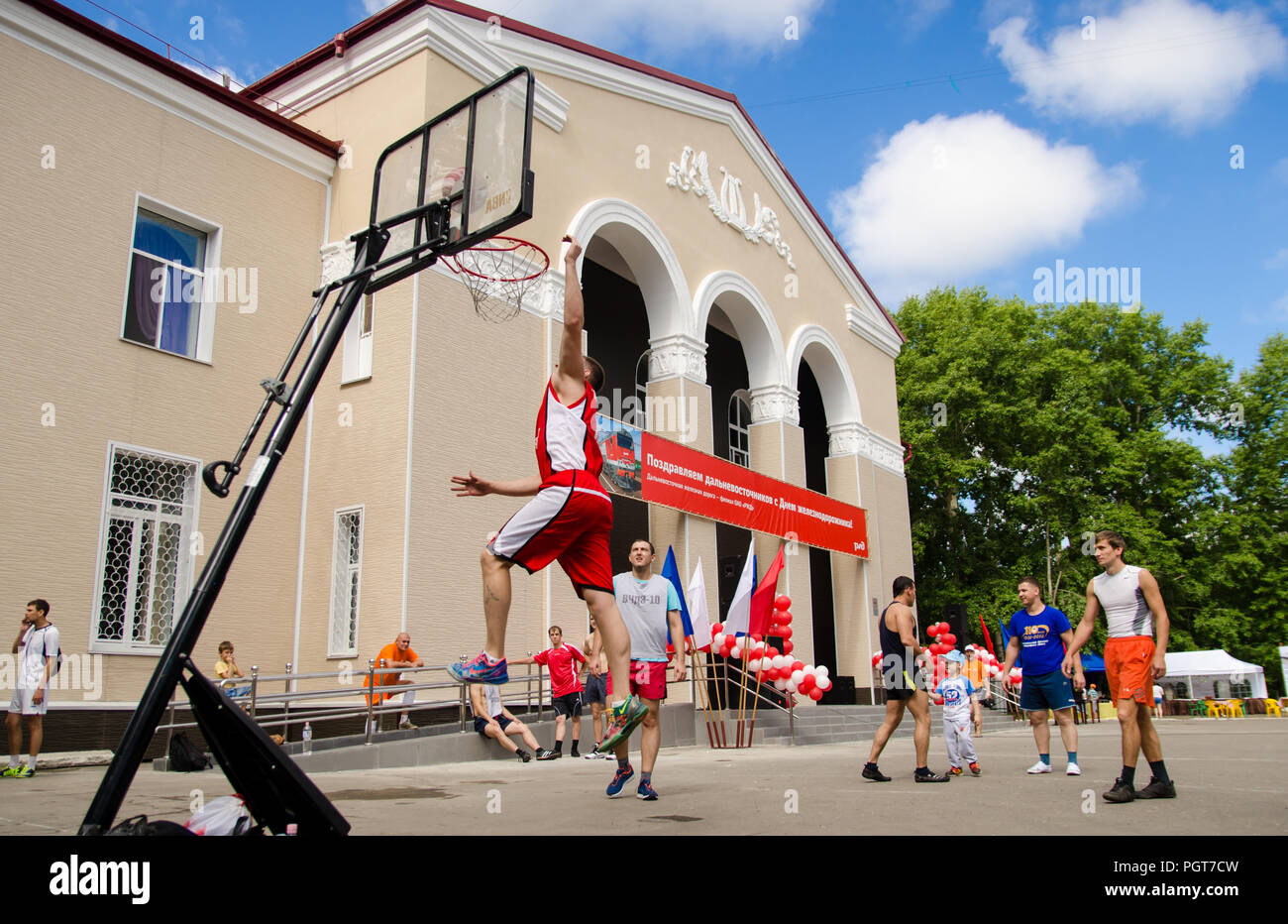Komsomolsk-on-Amur, Russia, 1 August 2015. Railroader's day. Young men play amateur basketball in summer. Low point shooting Stock Photo