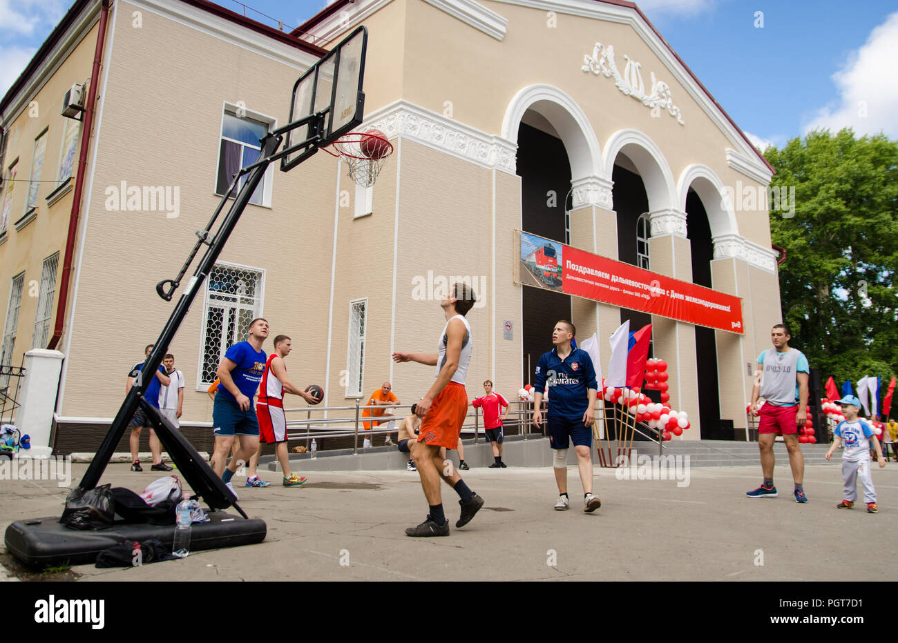 Komsomolsk-on-Amur, Russia, 1 August 2015. Railroader's day. Young men play amateur basketball in summer. Low point shooting Stock Photo