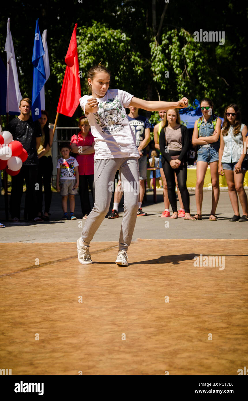 Komsomolsk-on-Amur, Russia, 1 August, 2015. girl dances breakdance in the square with spectators Stock Photo