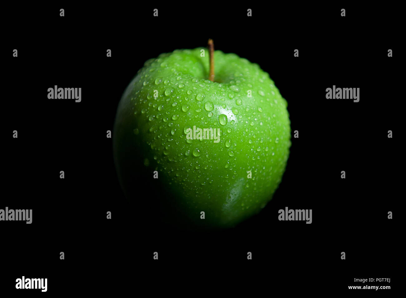 Wet droplets on green granny smith apple with black background Stock Photo