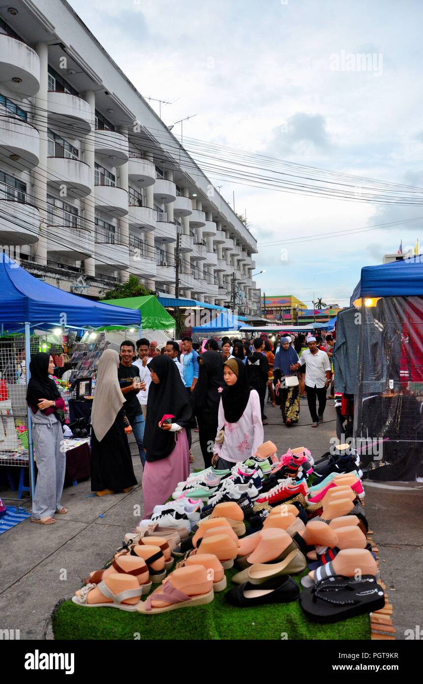 Crowds of people hang around outdoor street market shops & food stalls