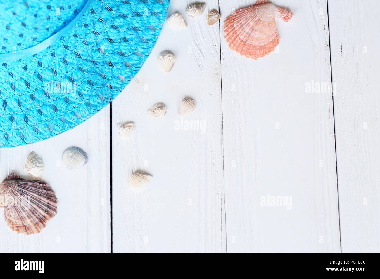 straw hat and seashells on wooden background.photo with place for text ...