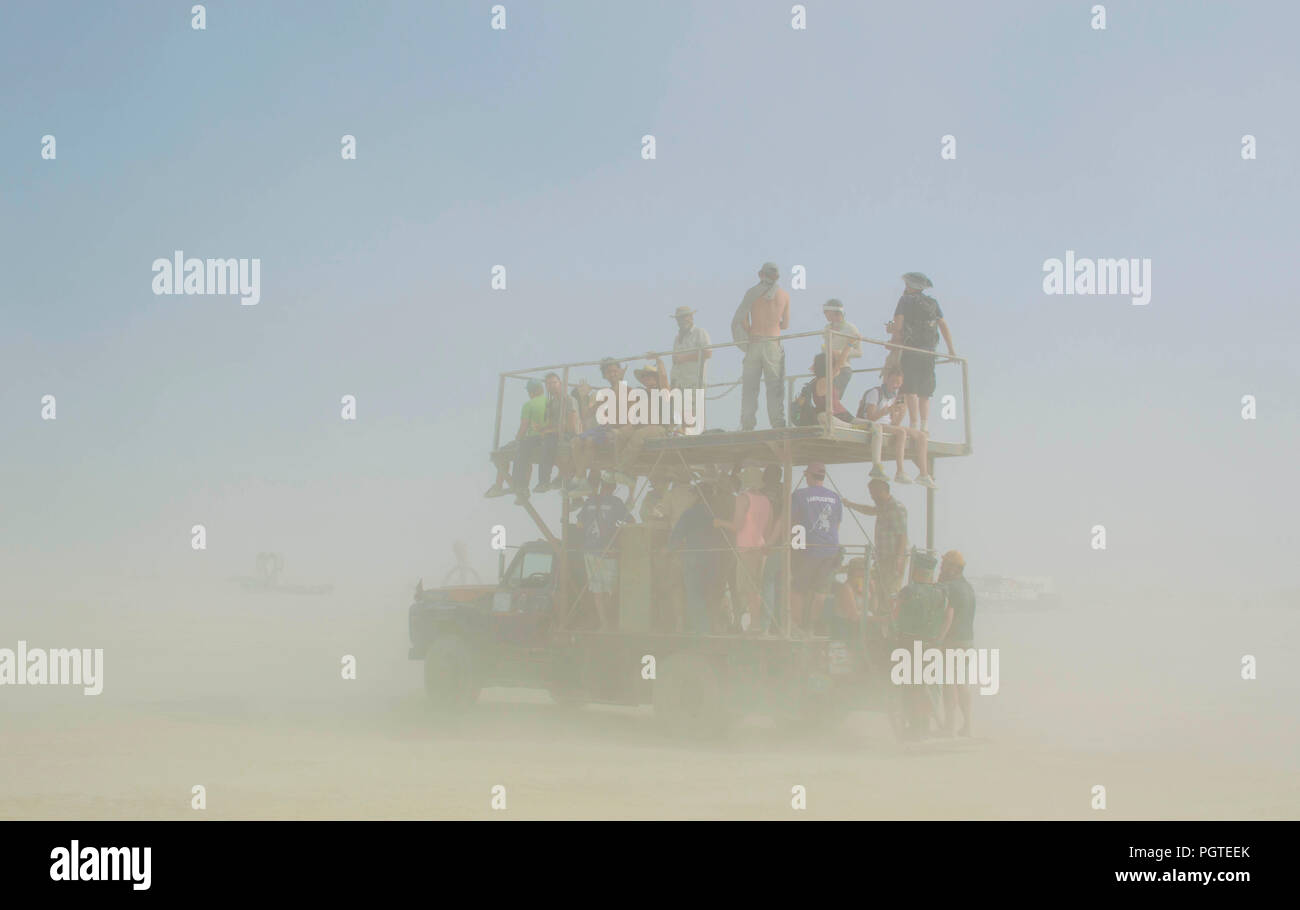 Burners drive through a dust storm in a mutant vehicle at the annual Burning Man counter culture festival in the desert August 24, 2018 near Black Rock, Nevada. Each year 80,000 of people set up a temporary art city in the middle of the desert. Stock Photo