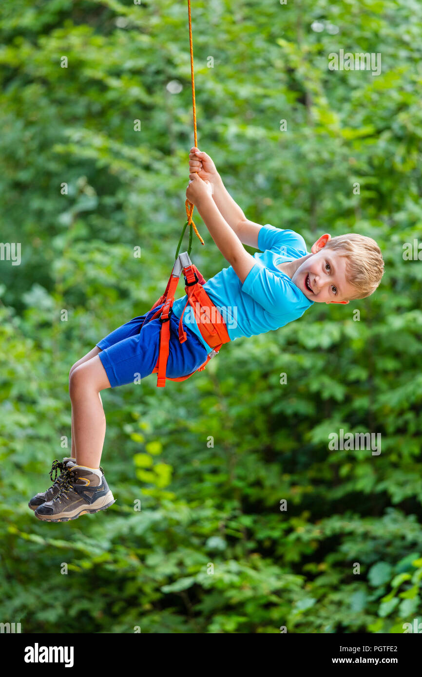 kid enjoy climbing tree in adventure park Stock Photo