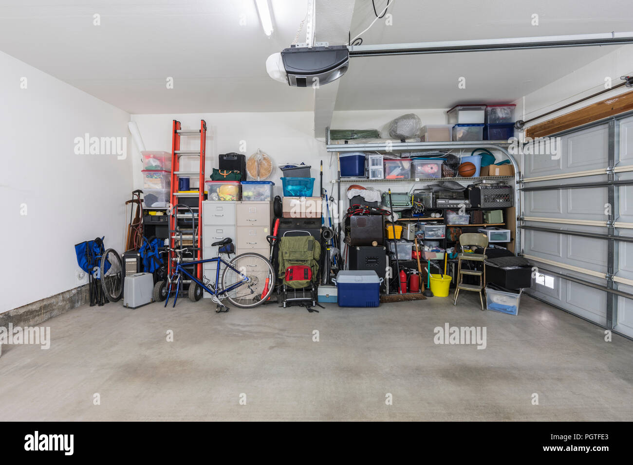 Cluttered but organized clean suburban residential two car garage with tools, file cabinets and sports equipment. Stock Photo