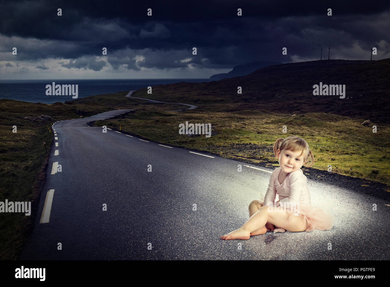 adorable kid with ballet clothes sit on long lonely road Stock Photo