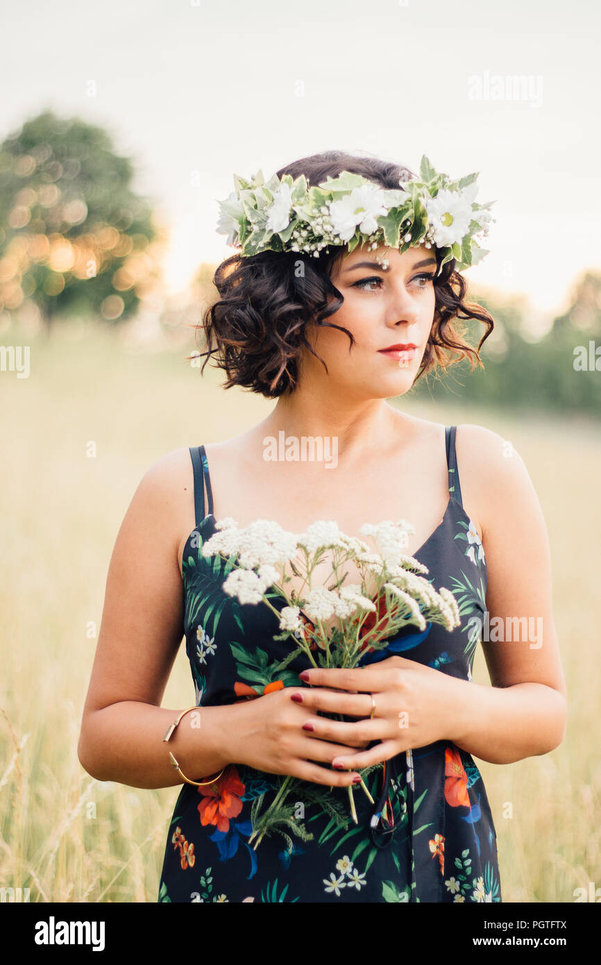 Girl with flower crown posing in the field during sunset Stock Photo - Alamy
