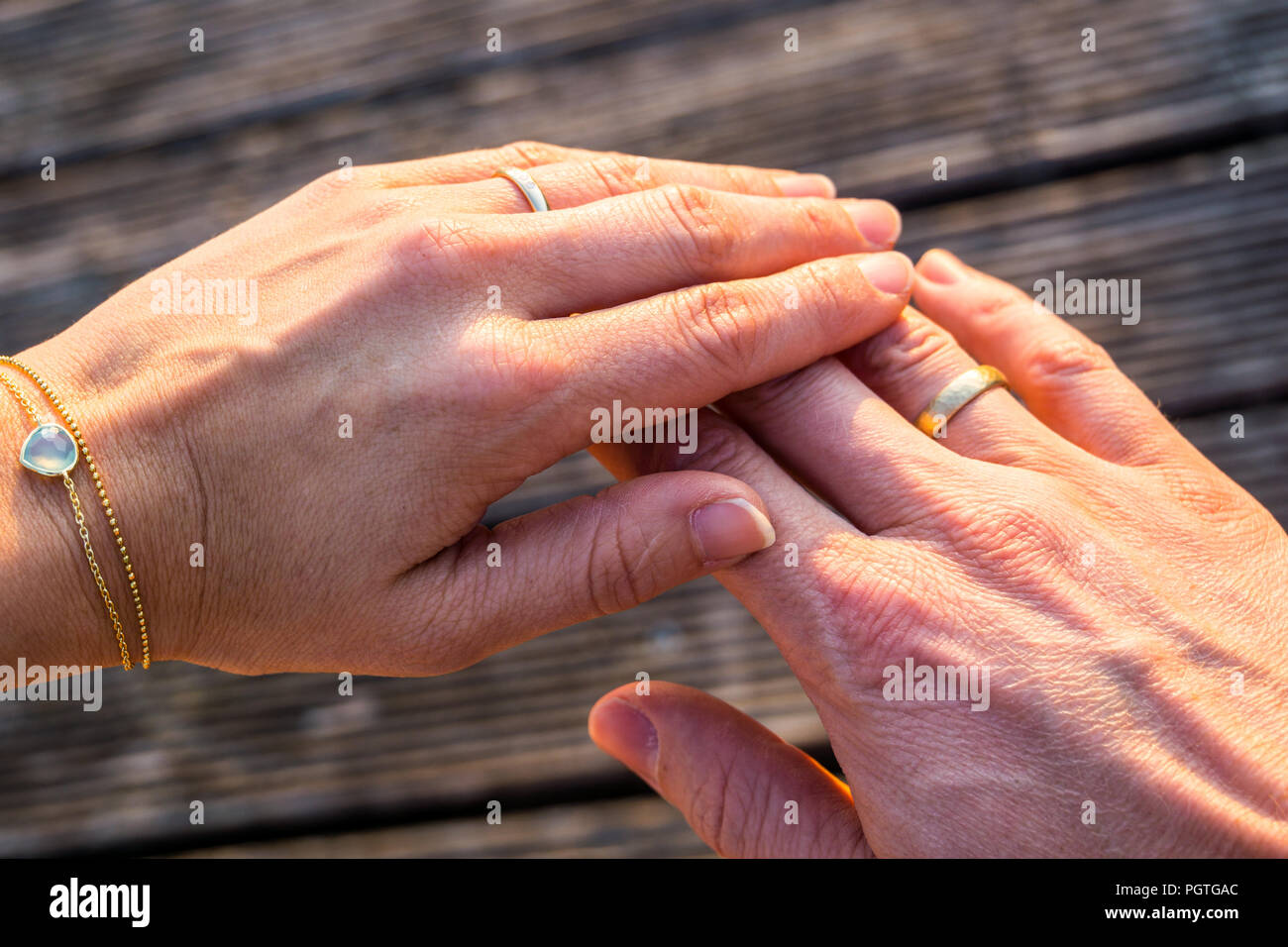 Two hands with golden rings for eternal love Stock Photo