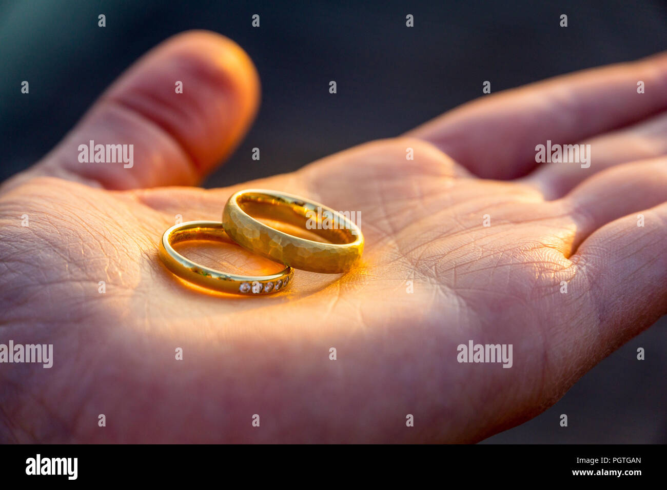 Hand holding two golden marriage rings as symbol for eternal love Stock Photo