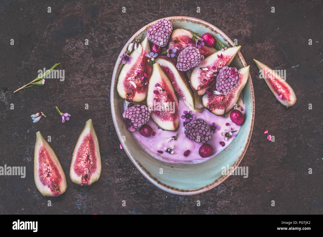 Healthy breakfast bowl with yogurt, fresh figs and frozen berries Stock Photo