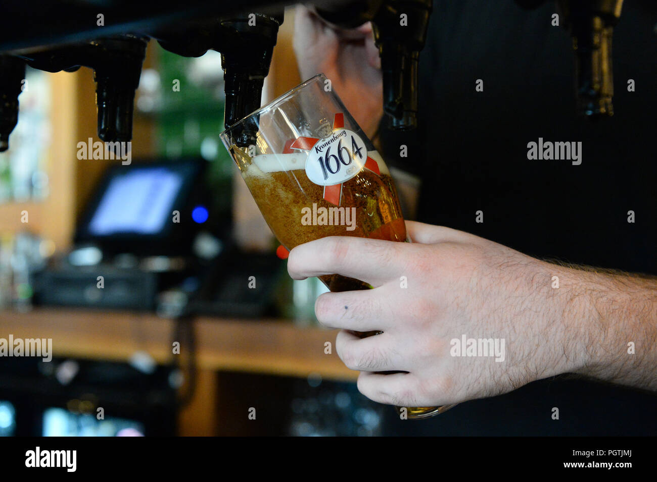 A bar tender pours a Kronenbourg beer in a pub in Fulham, London. Stock Photo
