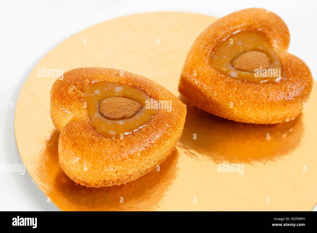 Nuts cake heart-shaped. Piece of Cake with almond ant peanut on a Plate.  Sweet food. Sweet dessert. Food background. Close up Stock Photo - Alamy