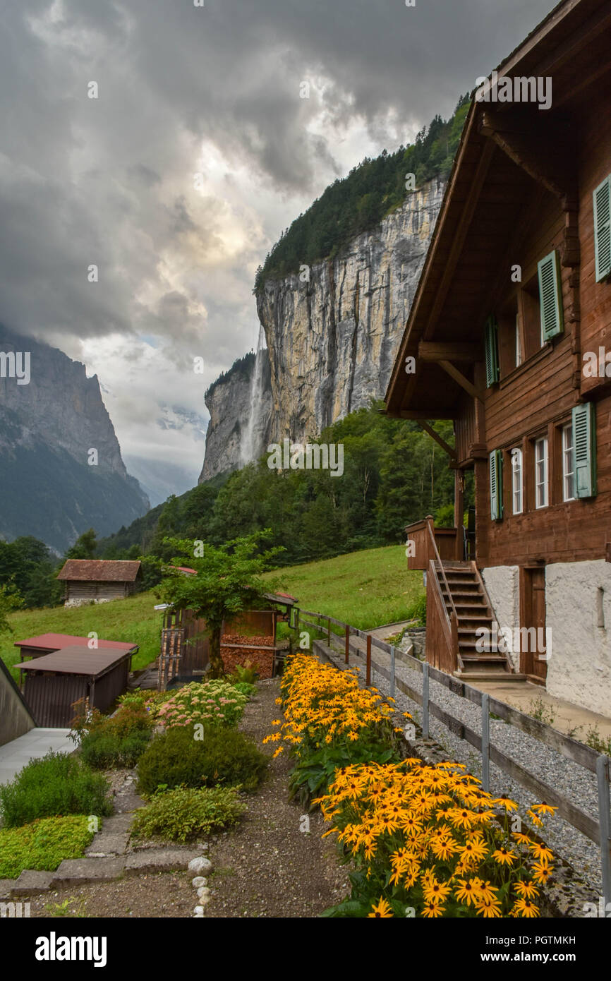 Idyllic view of wooden mountain farm houses in the Swiss Alps, waterfall in the background Stock Photo
