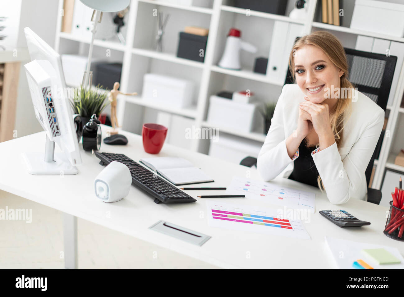 A young girl is sitting at the computer desk in the office Stock Photo ...