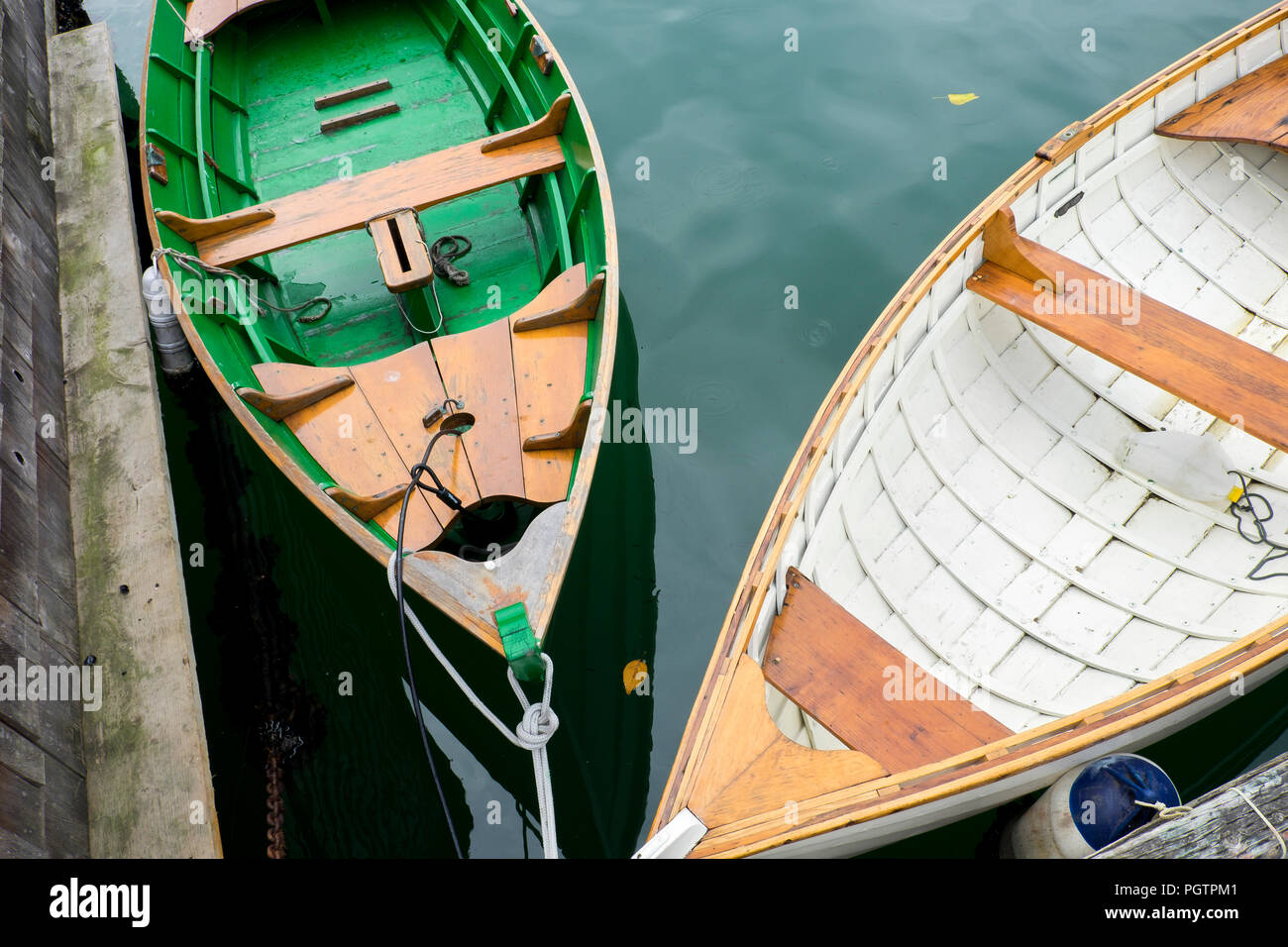 Looking down on two old wooden row boats one green the other white in Vancouver British Columbia. Stock Photo