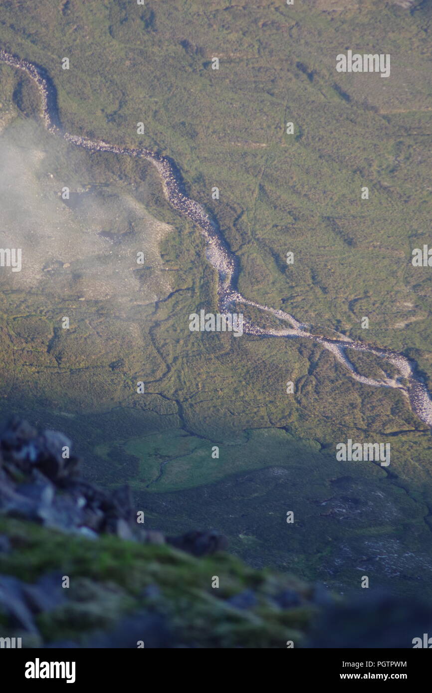 Meandering Burn Stream along the Valley Floor Under Slight Cloud Inversion. Birds Eye View from Meall a'Ghiubhais Mountain. Kinlochewe, Torridon, UK. Stock Photo