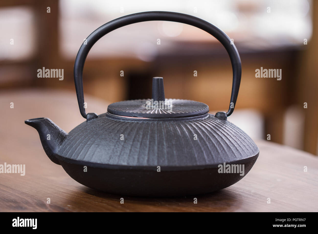 Traditional Black cast iron teapot on a table top Stock Photo
