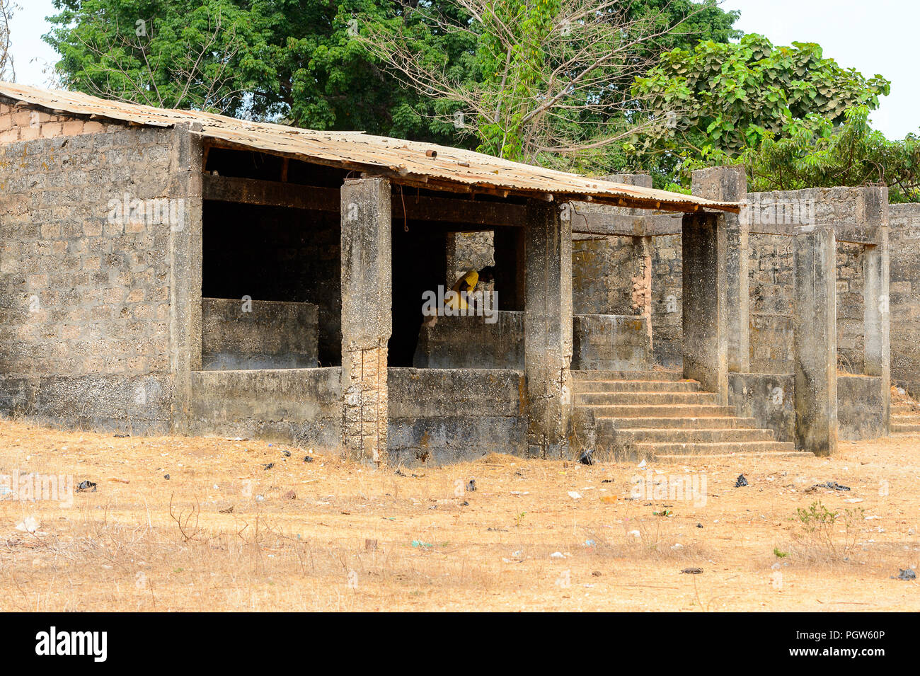 BUBAQUE, GUINEA BISSAU - MAY 5, 2017: Unidentified local man in yellow shirt stands in the unbuilt building in a village of the Bubaque island. People Stock Photo