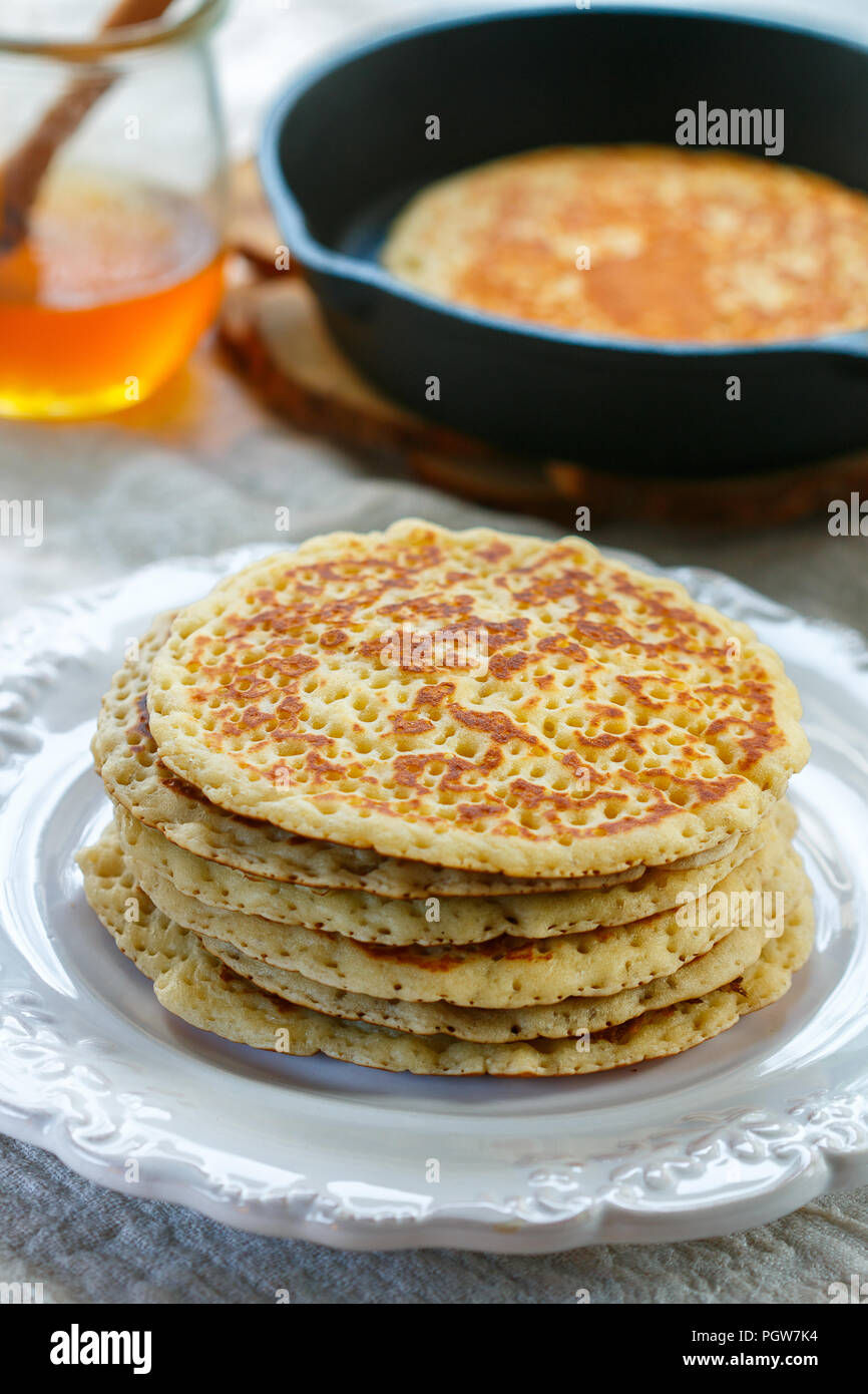 Delicious sweet American pancakes with honey on a white plate. Breakfast is gourmet. Selective focus Stock Photo
